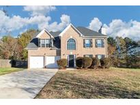 Brick two-story house with attached two-car garage and landscaping at 116 Rolling Meadows Ct, Hampton, GA 30228