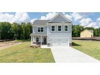 Two-story house with gray siding, a two-car garage, and a landscaped lawn at 3328 Pepperpike Ct, Loganville, GA 30052