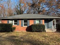 Brick ranch home with dark shutters, landscaping, and a spacious yard at 721 Yale Sw Pl, Atlanta, GA 30315