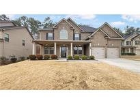 Brick two-story house with a front porch and attached two-car garage at 607 Stream Ct, Fairburn, GA 30213