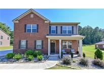 Brick two-story house with landscaped yard and porch at 1468 Harlequin Way, Stockbridge, GA 30281