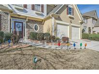 Two-story house with stone accents, three-car garage, and landscaped yard at 2331 Flowerdale Ct, Douglasville, GA 30135