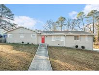 Ranch style home with a red door and landscaped yard at 3686 Thurman Rd, Atlanta, GA 30349