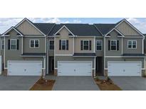 Three-unit townhome building with attached garages and neutral color palette at 1080 Cades Walk, Lawrenceville, GA 30045