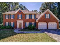 Brick two-story house with a two-car garage and landscaped lawn at 4220 Singing Post Ne Ln, Roswell, GA 30075