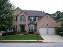 Brick two-story house with a two-car garage and manicured lawn at 4400 Bellwood Cir, South Fulton, GA 30349