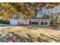 Ranch style home with red front door, attached garage, and well-manicured lawn at 2330 Dorsey Ave, Atlanta, GA 30344