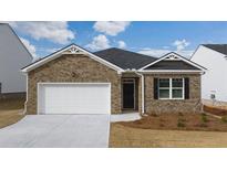 Brick house with a two-car garage and landscaping at 540 Whitman Ln, Stockbridge, GA 30281