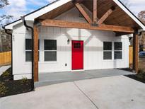 White farmhouse exterior with a red door, wood beams, and a covered porch at 860 Gardner Sw St, Austell, GA 30168