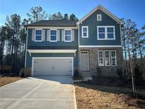 Two-story house with blue siding, stone accents, and a gray door at 7260 Eton Ln, Locust Grove, GA 30248