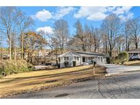 Ranch style home with gray brick exterior, landscaping, and driveway at 2702 Norma Cir, Decatur, GA 30034