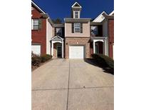 Two-story brick townhome with attached garage and driveway at 2429 Birkhall Way, Lawrenceville, GA 30043