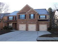 Brick house with three-car garage and a large driveway at 8178 Lochley Dr, Fairburn, GA 30213
