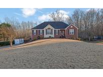 Brick ranch home with landscaped yard and driveway at 6275 Dexters Dr, Cumming, GA 30040