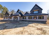 Brick house with a large front porch and a dark-colored roof at 1730 Etchison Spur, Loganville, GA 30052