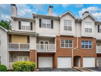 Brick and siding townhouse exterior with attached garage and balcony at 308 Spring Heights Lane # 308, Smyrna, GA 30080