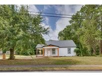 Charming white cottage with a covered porch and landscaped yard at 1183 Highway 138, Jonesboro, GA 30236