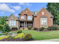 Brick home with stone accents, landscaping, and a large front yard at 3006 Cambridge Hill Dr, Dacula, GA 30019