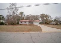 Ranch home with red metal roof, attached garage, and spacious yard at 70 E Honeysuckle Ln, Carrollton, GA 30116