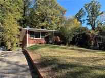 Brick ranch house with a driveway and a spacious yard at 2028 Wells Sw Dr, Atlanta, GA 30311