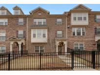 Brick front exterior of townhome with a black metal fence and landscaping at 2065 Morrison Ave, Brookhaven, GA 30319