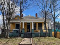 Yellow house with wrap-around porch and mature trees at 1786 Lakewood Ave, Atlanta, GA 30315