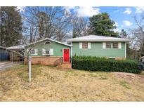 Ranch home with green siding, red door and landscaping at 282 Evelyn Nw St, Marietta, GA 30064