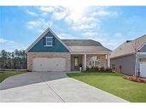 Brick and blue-sided house with a two-car garage and landscaped lawn at 90 Colonial Ter, Villa Rica, GA 30180