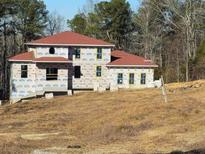 Two-story house under construction, red roof, and large windows at 515 Penny Ln, Loganville, GA 30052