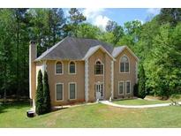 Two story house with beige exterior, large windows, and a landscaped yard at 4365 Miners Creek Rd, Lithonia, GA 30038
