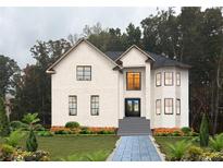 Two-story house with white brick exterior, landscaping, and a stone walkway at 409 Saint Surrey Way, Ellenwood, GA 30294