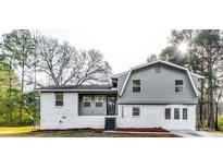 Newly renovated house featuring gray siding, white brick, and a landscaped yard at 6685 Buckhurst Trl, Atlanta, GA 30349