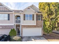 Two-story townhome with stone and siding exterior, attached garage, and balcony at 3112 Spicy Cedar Ln, Lithonia, GA 30038