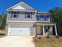 Two-story house with gray siding, white garage door, and landscaping at 55 Heyman Dr, Covington, GA 30016