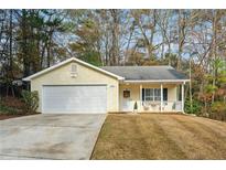 Cute yellow house with a 2-car garage and front porch at 5862 Homestead Cir, Rex, GA 30273