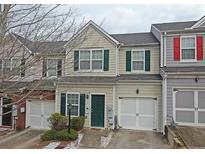 Tan townhome with green shutters, white garage doors, and landscaping at 230 Valley Xing, Canton, GA 30114