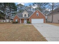 Brick house with a two-car garage and well-maintained lawn at 1085 Sunny Field Ct, Lawrenceville, GA 30043