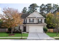 Two-story house with gray siding, white garage door, and landscaping at 3680 Shale Ln, Conyers, GA 30013