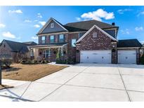 Brick two-story house with three car garage and landscaped yard at 1178 Fort Marcy Park, Lawrenceville, GA 30044
