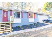 Newly painted blue brick ranch with red shutters, updated landscaping, and a two-car garage at 1065 Cherokee Trl, Woodstock, GA 30189