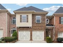 Brick front exterior of a two-story townhome with a two-car garage at 2368 Harshaw Ave # 166, Lawrenceville, GA 30043