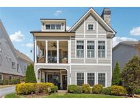 Two-story craftsman home with gray siding, shutters, and a covered porch at 5499 Vineyard Park Trl, Norcross, GA 30071