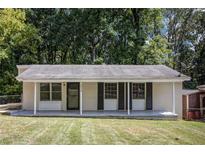 Ranch style home with a covered porch and landscaped yard at 4218 Tara Dr, Forest Park, GA 30297