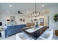 Open concept dining area with a large black table and white chairs, adjacent to the living room and kitchen at 401 Carrera Ln, Acworth, GA 30102