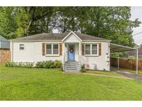 Charming white brick ranch home with a blue door, landscaped lawn, and carport at 723 Campbell Cir, Hapeville, GA 30354