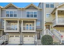 Two-story townhouses with front porches and attached garages at 2015 Liberty Nw Ct, Atlanta, GA 30318