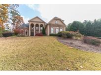 Brick home on a sloping lot with landscaping and a two-car garage at 110 Robinwood Ct, Fayetteville, GA 30214