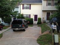 Tan and light blue townhouses with a dark-colored SUV parked in the driveway at 295 Flagstone Way # 295, Austell, GA 30168