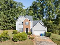 Two-story house with gray siding, brick accents, and a two-car garage at 3362 Eastmont Ln, Lithonia, GA 30038