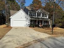 Two-story house with gray siding, white garage door, and landscaping at 2784 Lakeside Sw Dr, Conyers, GA 30094